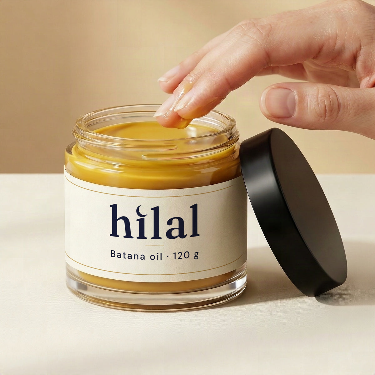 Warm and massage: a fingertip dips into an open jar of Hilal batana oil