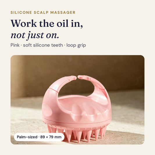 Pink silicone scalp massager with soft silicone teeth and a loop grip